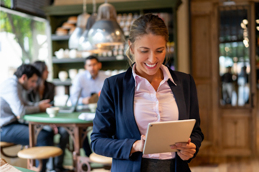 Restaurant manager using ShiftNote, checking shifts on tablet.